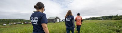 people walking through a farm field